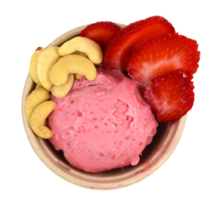 Scoop of strawberry ice cream in bowl with ingredients.